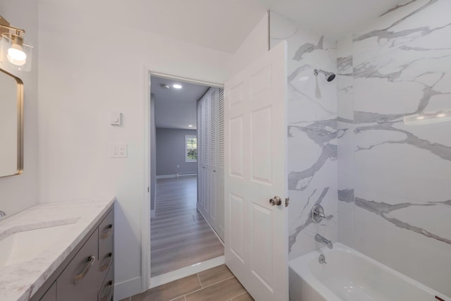 bathroom with vanity, washtub / shower combination, recessed lighting, and wood finished floors