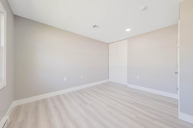 empty room with recessed lighting, light wood-style flooring, baseboards, and visible vents