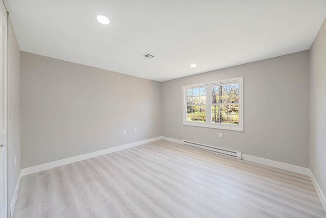 spare room with visible vents, baseboards, recessed lighting, a baseboard heating unit, and light wood finished floors