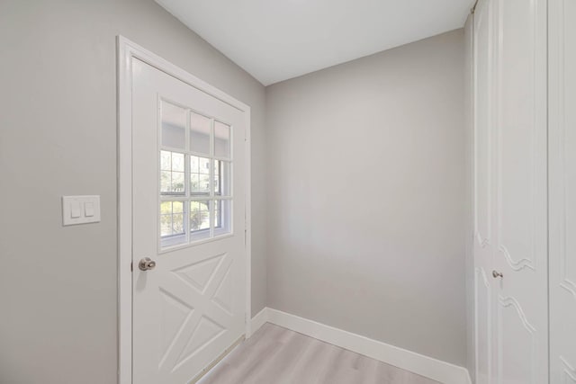 doorway to outside with baseboards and light wood finished floors