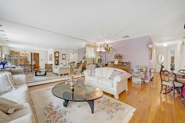 572 Scarsdale Rd, Tuckahoe, NY 10707 - living area with visible vents, light wood-style flooring, and an inviting chandelier