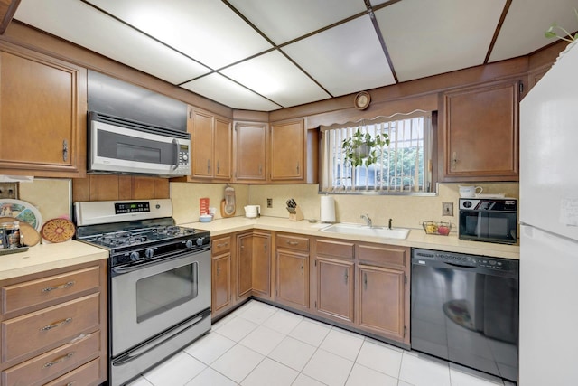 572 Scarsdale Rd, Tuckahoe, NY 10707 - kitchen featuring light countertops, appliances with stainless steel finishes, brown cabinets, and a sink