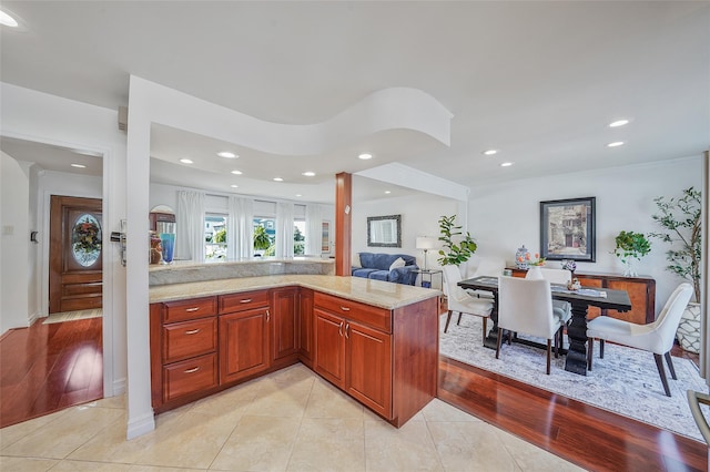 86 Jefferson Ave, Island Park, NY 11558 - kitchen featuring crown molding, light stone counters, recessed lighting, a peninsula, and light tile patterned floors