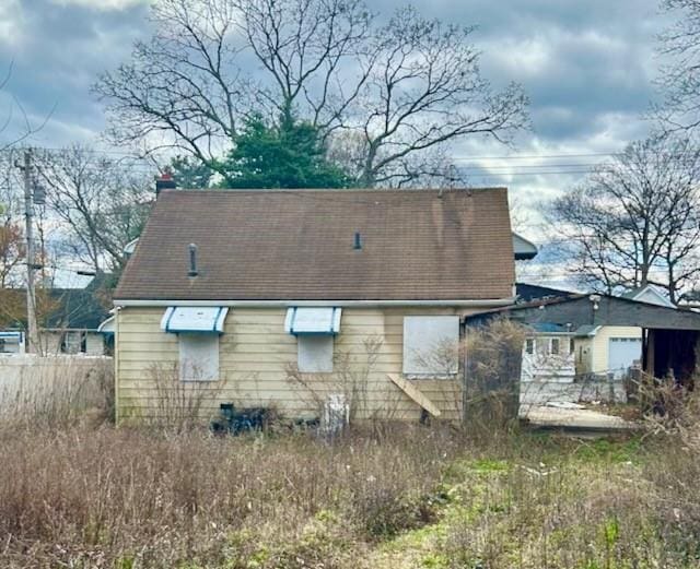rear view of property featuring fence and a garage