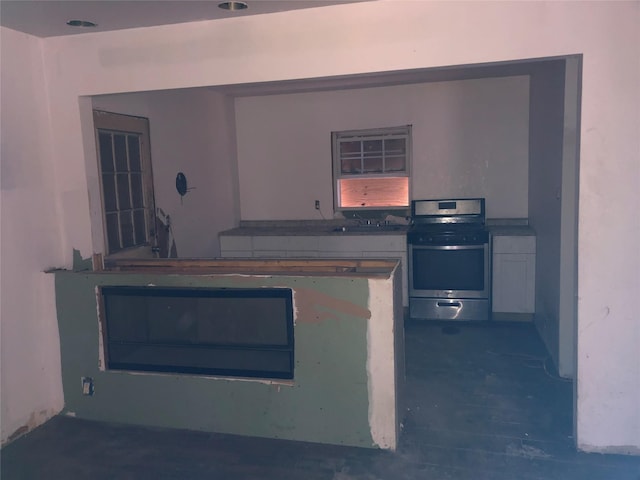 kitchen featuring stainless steel electric range oven, a sink, and wood finished floors