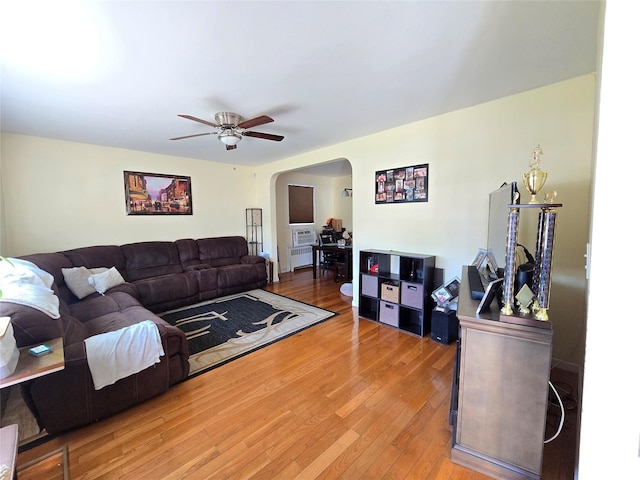 221-15 112th Ave, Queens Village, NY 11429 - living room with arched walkways, radiator heating unit, light wood-style flooring, and ceiling fan