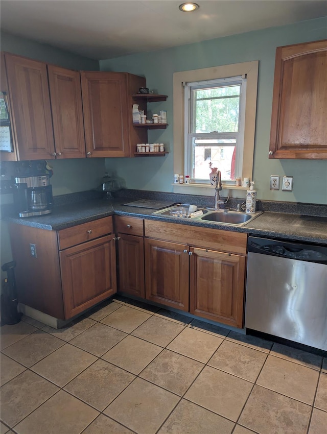 kitchen with dishwasher, a sink, dark countertops, light tile patterned floors, and brown cabinets