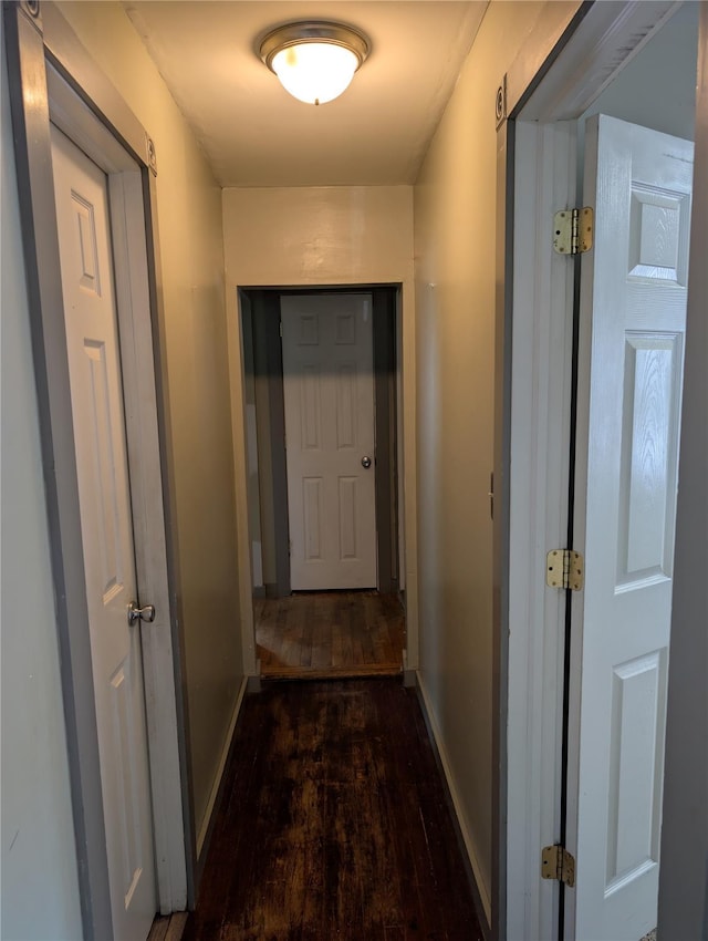 hallway featuring hardwood / wood-style floors and baseboards