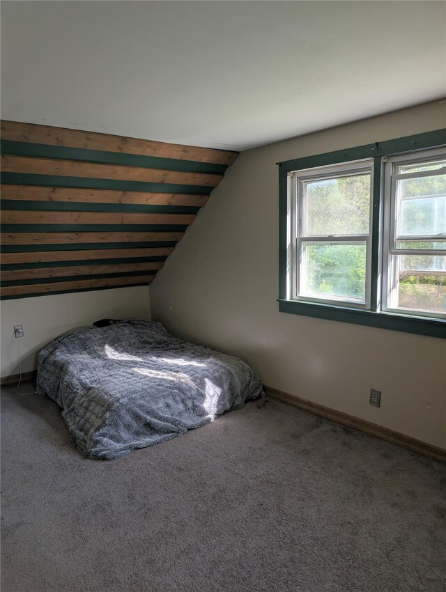 bedroom with carpet flooring, vaulted ceiling, and baseboards