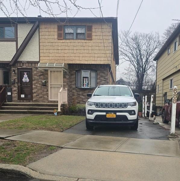 view of front facade with brick siding and driveway