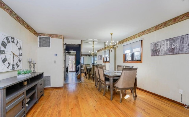 dining room with baseboards, a notable chandelier, visible vents, and light wood-type flooring