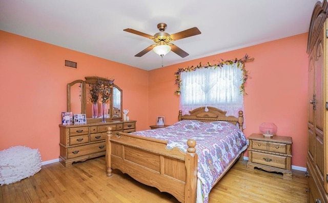 bedroom featuring baseboards, a ceiling fan, light wood finished floors, and visible vents