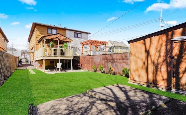 rear view of house featuring a fenced backyard, a patio, a lawn, and a wooden deck