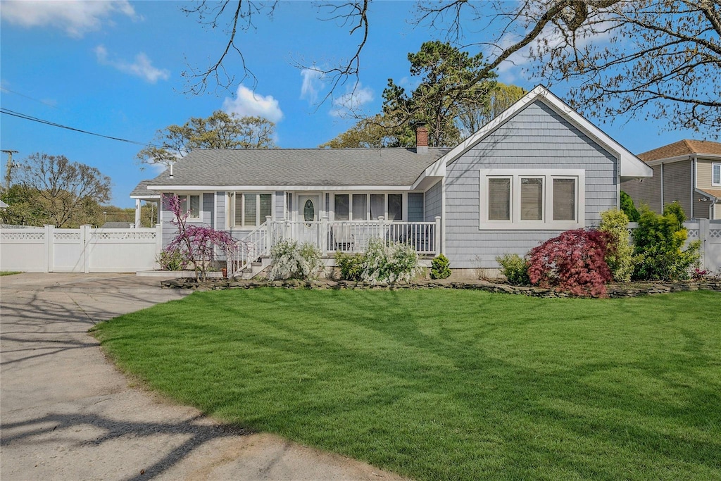 ranch-style house featuring fence, a chimney, and a front yard