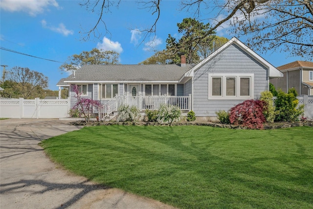 ranch-style house featuring fence, a chimney, and a front yard