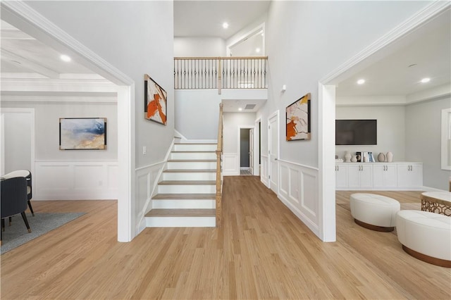 entryway featuring light wood-style floors, recessed lighting, a decorative wall, and stairway