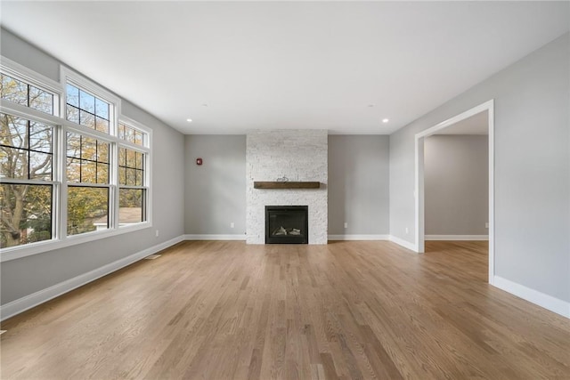 unfurnished living room with baseboards and light wood-style flooring