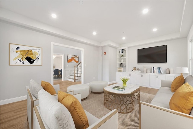 living room featuring light wood-style floors, recessed lighting, baseboards, and stairway