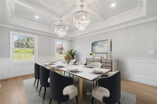 dining room featuring crown molding, a chandelier, light wood-style flooring, and coffered ceiling