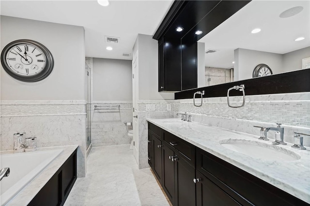 bathroom featuring a sink, tile walls, toilet, and visible vents