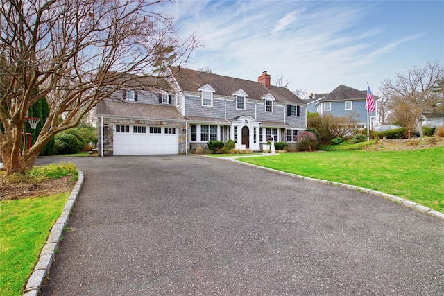 52 Northwoods Rd, Manhasset, NY 11030 - shingle-style home with asphalt driveway, a chimney, a front yard, and stone siding