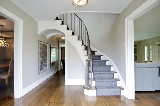 52 Northwoods Rd, Manhasset, NY 11030 - stairs featuring arched walkways, wood finished floors, ornamental molding, and baseboards