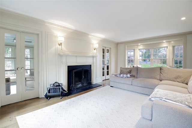 52 Northwoods Rd, Manhasset, NY 11030 - living area with crown molding, french doors, light wood finished floors, plenty of natural light, and a fireplace with raised hearth