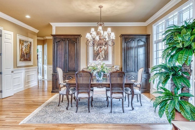 1640 Grandview Dr, Orient, NY 11957 - dining area with a chandelier, light wood-style flooring, ornamental molding, a wainscoted wall, and a decorative wall