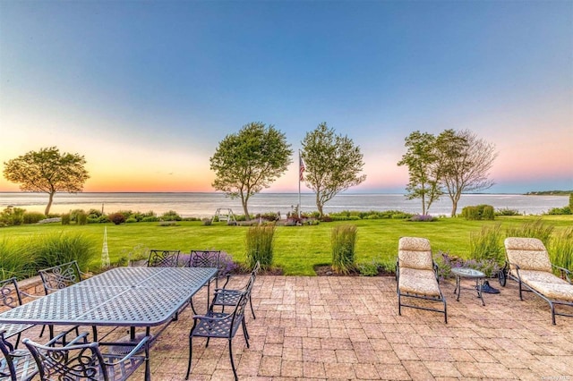 1640 Grandview Dr, Orient, NY 11957 - patio terrace at dusk featuring a water view, a patio, a lawn, and outdoor dining space