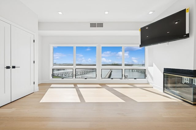 interior space featuring baseboards, plenty of natural light, light wood-style flooring, and visible vents