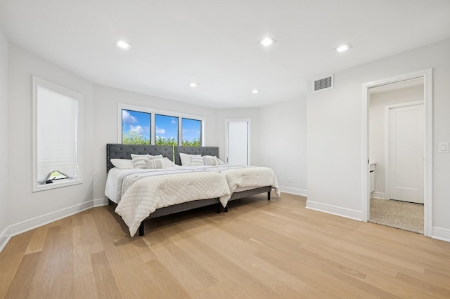 bedroom with baseboards, visible vents, and light wood-type flooring