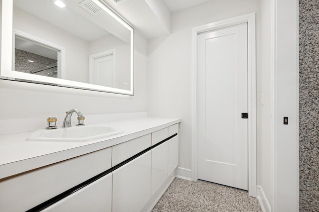 bathroom featuring baseboards, visible vents, speckled floor, and vanity