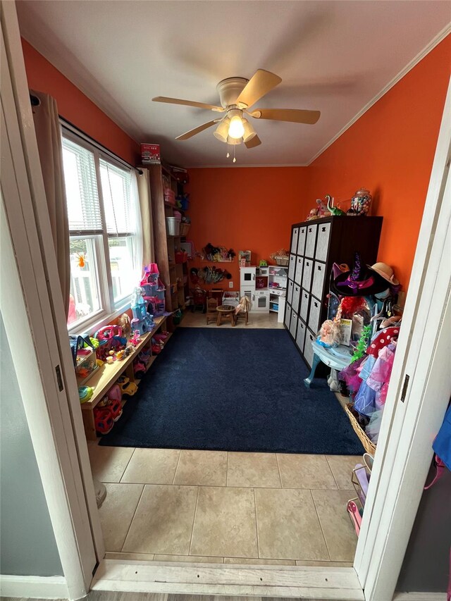rec room with tile patterned floors and a ceiling fan