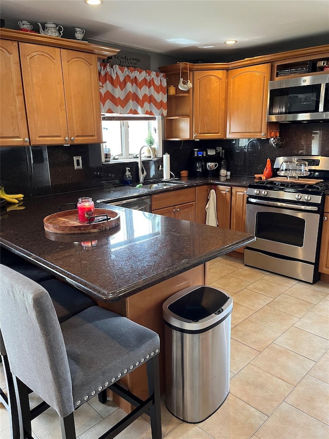 kitchen with a breakfast bar area, backsplash, open shelves, a sink, and stainless steel appliances