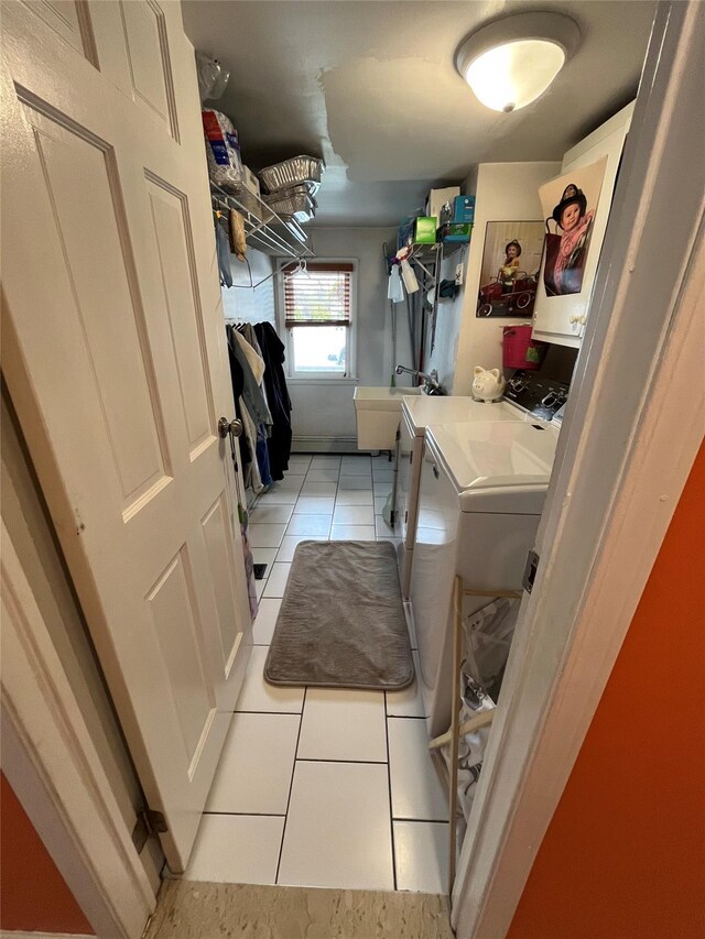 laundry area with washer and dryer, laundry area, and light tile patterned floors