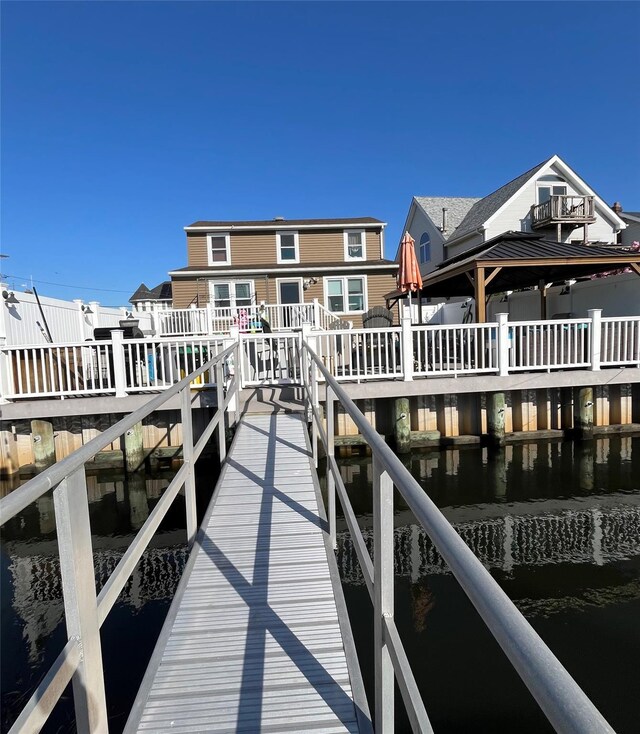 view of dock with a water view and a residential view