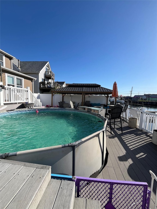 view of swimming pool with a fenced in pool and a wooden deck