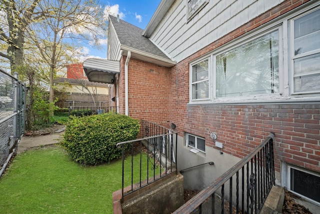 172-11 Horace Hadring Expy, Flushing, NY 11365 - exterior space featuring brick siding, a shingled roof, fence, and a yard