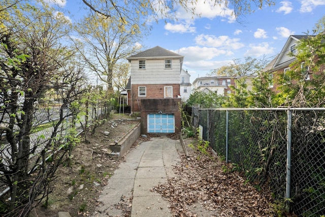 172-11 Horace Hadring Expy, Flushing, NY 11365 - view of side of property with a garage, fence, concrete driveway, and brick siding