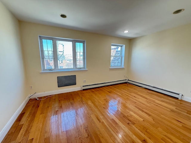 unfurnished room with wood-type flooring, recessed lighting, baseboards, and a baseboard radiator