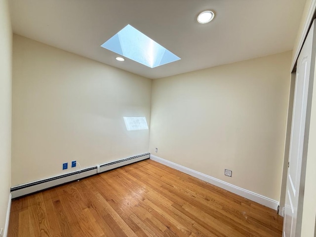 unfurnished room featuring baseboards, recessed lighting, a baseboard radiator, light wood-style flooring, and a skylight