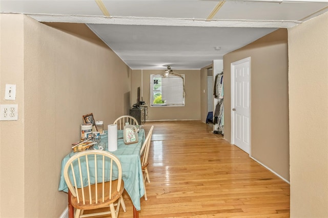 hallway featuring light wood-type flooring and baseboards