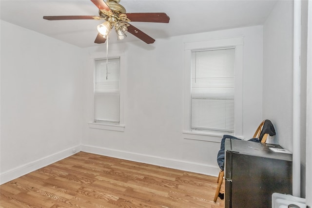 unfurnished office featuring ceiling fan, light wood-style flooring, and baseboards