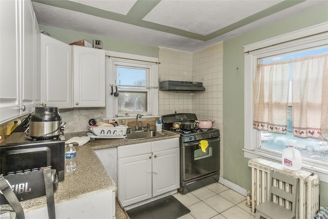 kitchen featuring black range with gas stovetop, radiator, a sink, under cabinet range hood, and white cabinets