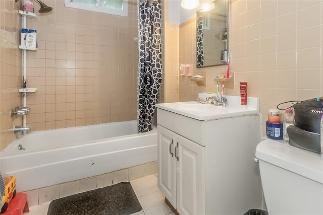 full bathroom with tile walls, shower / bath combination with curtain, tile patterned floors, toilet, and vanity