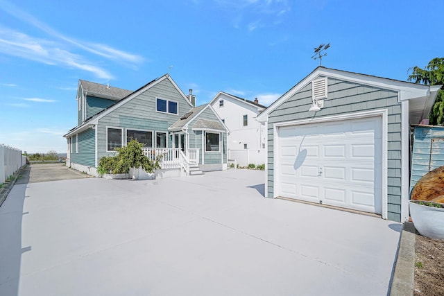 7 Grandview Dr, Shirley, NY 11967 - view of front facade with fence, an outdoor structure, a detached garage, concrete driveway, and covered porch
