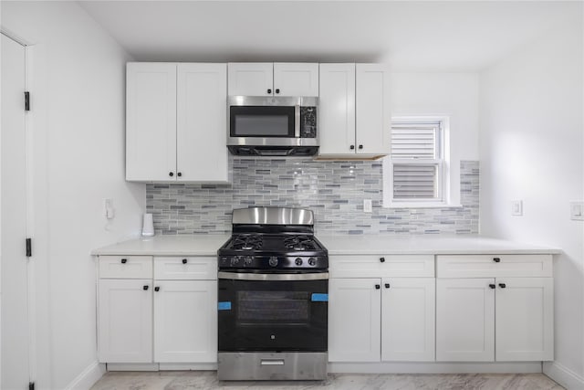 186-09 Dormans Rd, Saint Albans, NY 11412 - kitchen with light countertops, white cabinets, stainless steel appliances, and tasteful backsplash