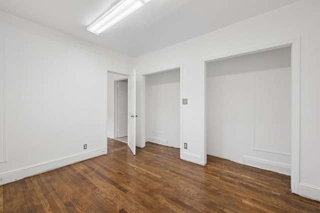 31-50 Buell, East Elmhurst, NY 11369 - unfurnished bedroom with wood finished floors, baseboards, and two closets