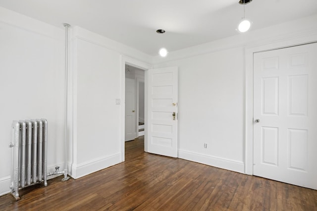 31-50 Buell, East Elmhurst, NY 11369 - unfurnished room with radiator heating unit, dark wood-type flooring, and baseboards