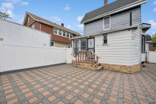31-50 Buell, East Elmhurst, NY 11369 - back of property featuring a patio, a fenced backyard, and a chimney